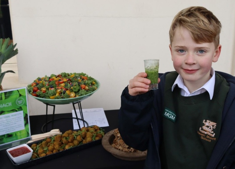 Child drinks spinach smoothie to celebrate nutrition day and healthy eating at Heath Mount